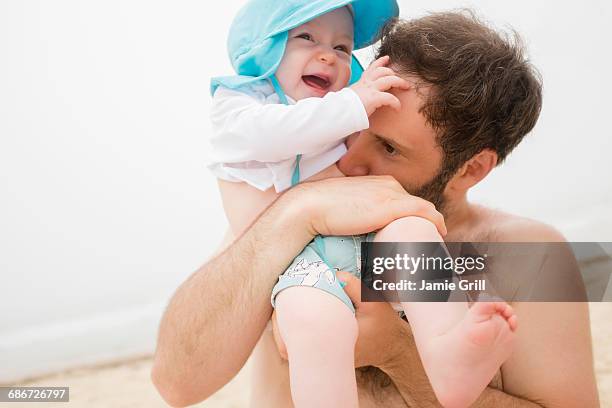 father kissing baby son (6-11 months) on stomach - 6 11 monate stock-fotos und bilder