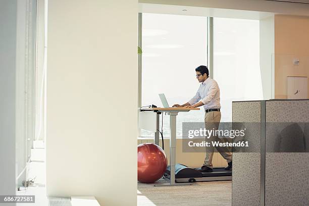 businessman training on tread mill while using laptop - walking treadmill stock pictures, royalty-free photos & images