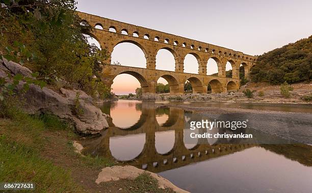 pont du gard aqueduct reflections in gardon river, france - pont du gard aqueduct stock-fotos und bilder