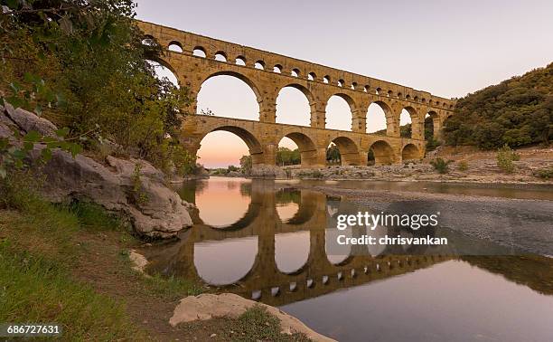 pont du gard aqueduct reflections in gardon river, france - chrisvankan stock pictures, royalty-free photos & images