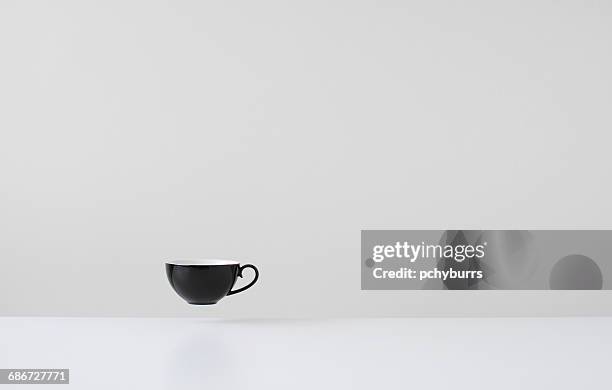 black coffee cup floating mid air - pchyburrs stock pictures, royalty-free photos & images