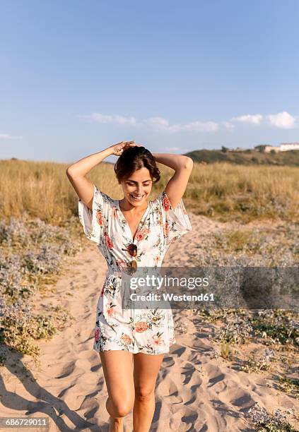 smiling woman on the beach at evening twilight - vestido de verão imagens e fotografias de stock