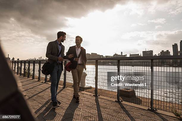 usa, new york city, two businessmen walking along east river - panorama nyc day 2 foto e immagini stock