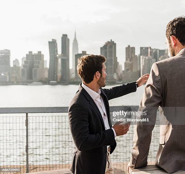 usa, new york city, businessman talking to colleague at east river - ragazzo new york foto e immagini stock