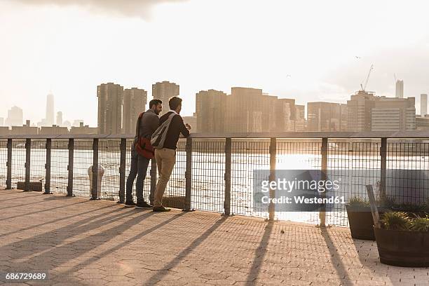 usa, new york city, two young men talking at east river - panorama nyc day 2 foto e immagini stock