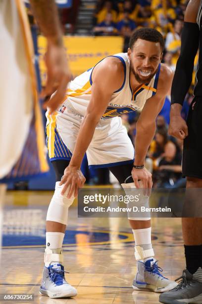 Stephen Curry of the Golden State Warriors smiles and looks on in Game One of the Western Conference Finals against the San Antonio Spurs during the...