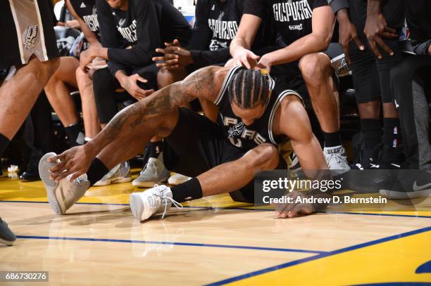 Kawhi Leonard of the San Antonio Spurs grabs his legs after an injury in Game One of the Western Conference Finals against the Golden State Warriors...