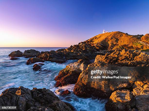 australia, new south wales, port macquarie, lighthouse on rocky coat at sunrise - port macquarie stock pictures, royalty-free photos & images