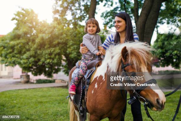 excited young girl taking a pony ride - pony stock pictures, royalty-free photos & images
