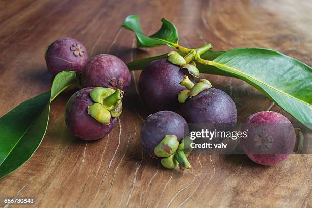 mangosteen fruit on a wooden table - mangosteen stockfoto's en -beelden