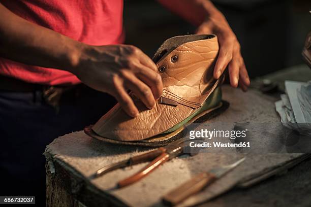 shoemaker working on shoe in workshop - shoe repair stockfoto's en -beelden