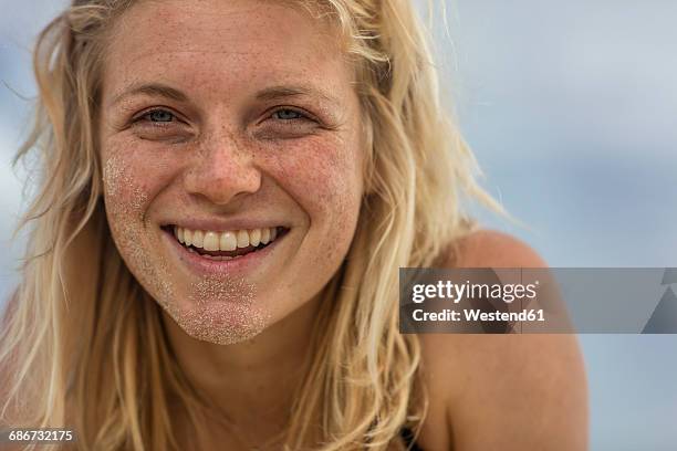 portrait of happy young woman with sand in her face - head in sand stock-fotos und bilder