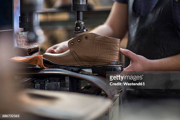 shoemaker working on shoe in workshop - zapato de cuero fotografías e imágenes de stock