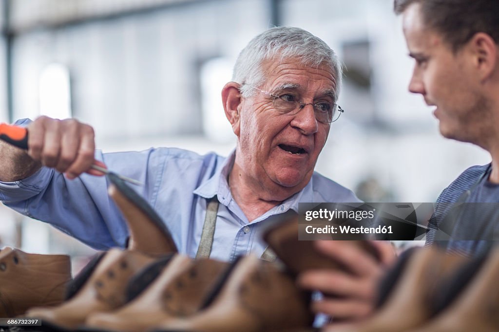 Two shoemakers talking in workshop