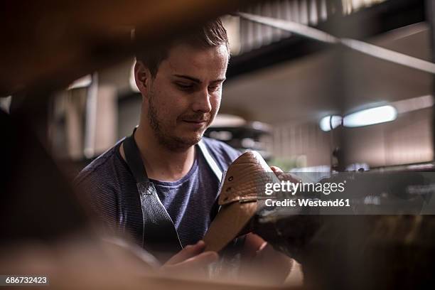 shoemaker working on shoe in workshop - shoe factory stock-fotos und bilder