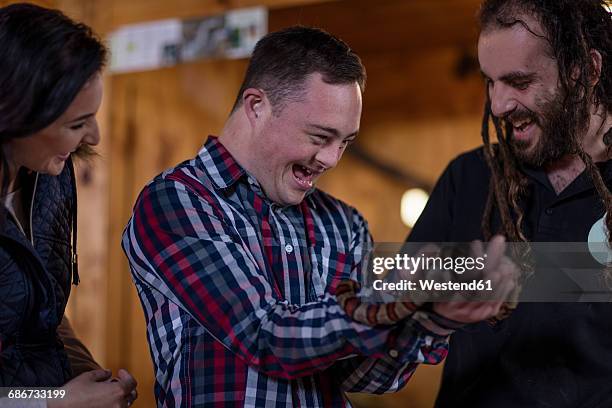 animal attendant handing over coral snake to young man with down syndrome - coral snake fotografías e imágenes de stock