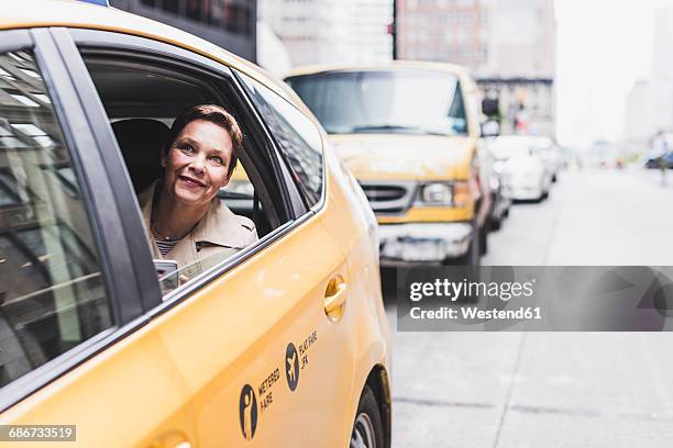 usa, new york city, smiling woman in taxi - yellow cab stock pictures, royalty-free photos & images