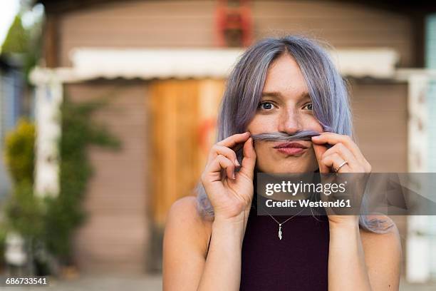 portrait of playful young woman with dyed hair - bart stock-fotos und bilder