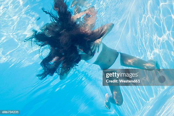 young woman underwater in a pool - long hair underwater stock pictures, royalty-free photos & images