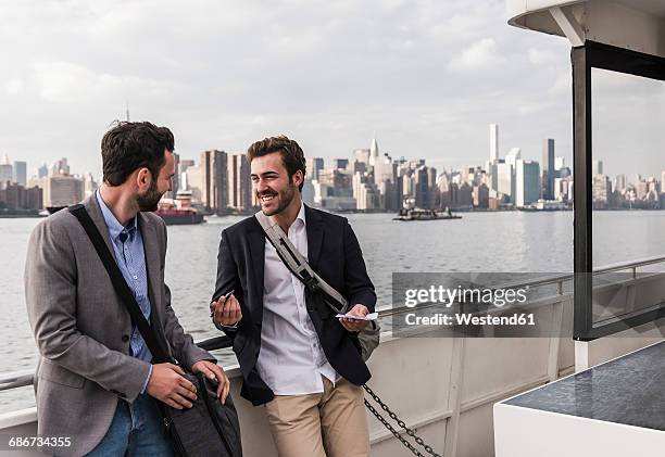 usa, new york city, two smiling businessmen talking on ferry on east river - panorama nyc day 2 foto e immagini stock