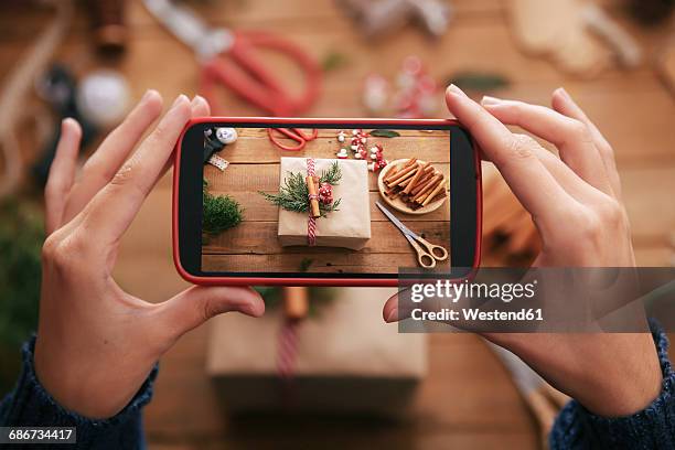 woman photographing decorated christmas gift with smartphone, close-up - mensaje de móvil fotografías e imágenes de stock