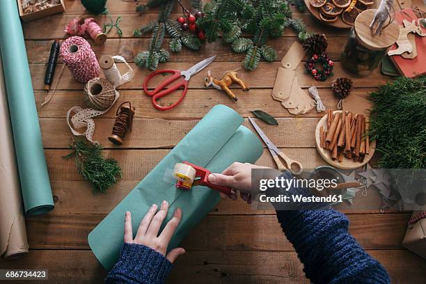 woman's hands wrapping christmas gifts - klebeband stock-fotos und bilder