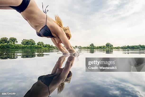 woman jumping into water - river bathing imagens e fotografias de stock
