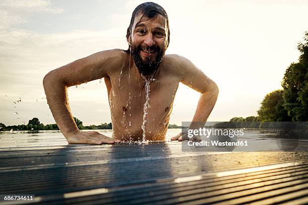 man getting out of water on jetty - water cooler stock-fotos und bilder