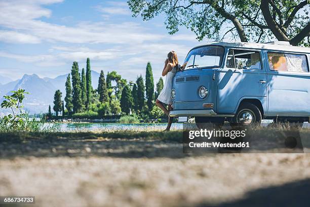 italy, lake garda, young woman drinking coffee at camping bus - camping bus stock-fotos und bilder