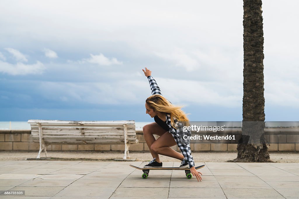 Young woman balancing on skateboard