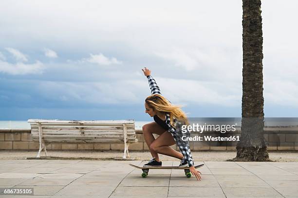 young woman balancing on skateboard - only young women stock pictures, royalty-free photos & images