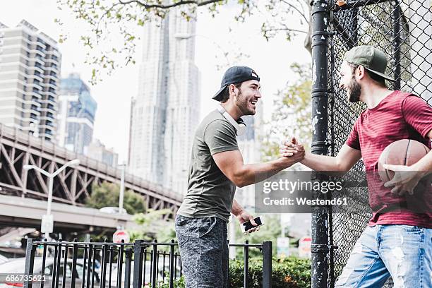 two young men with basketball meeting outdoors - fences 2016 film stock-fotos und bilder