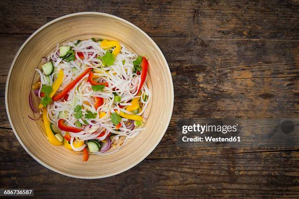 bowl of glass noodle salad with vegetables on dark wood - vermicelle chinois photos et images de collection