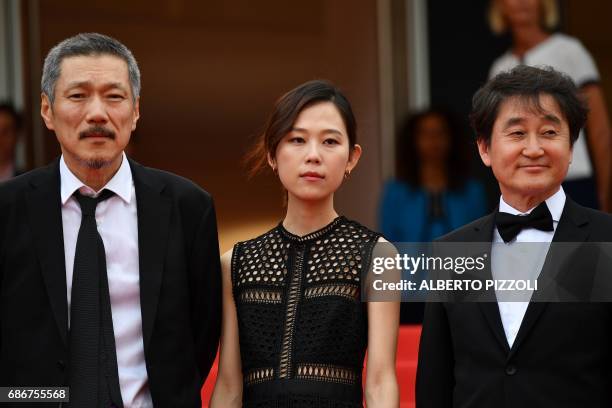 South Korean director Hong Sangsoo, South Korean actress Kim Sae-byeok and South Korean cinematographer Kim Hyung-koo pose as they arrive on May 22,...