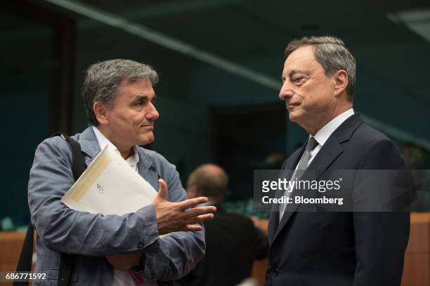 Euclid Tsakalotos, Greece's finance minister, left, gestures as he speaks with Mario Draghi, president of the European Central Bank , ahead of a...