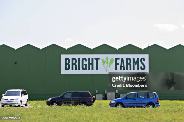 Vehicles sit parked outside the BrightFarms Inc. Chicagoland greenhouse in Rochelle, Illinois, U.S., on Friday, May 12, 2017. The BrightFarms...