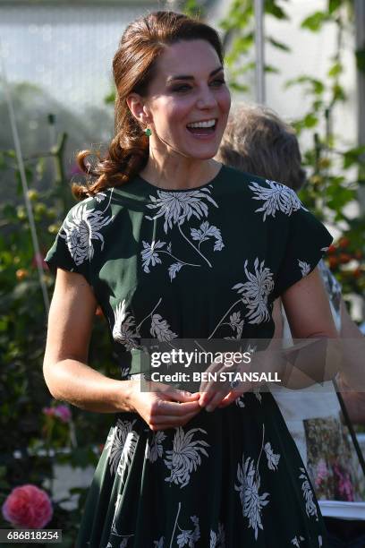 Britain's Catherine, Duchess of Cambridge, reacts after trying a tomato at the 'BBC Radio 2: Chris Evans Taste Garden' during her visit to the...