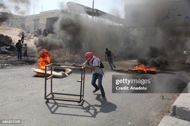 Palestinian demonstrators, who stage a demonstration in support of Palestinian prisoners held in Israeli jails, throw rocks and burn tires in...