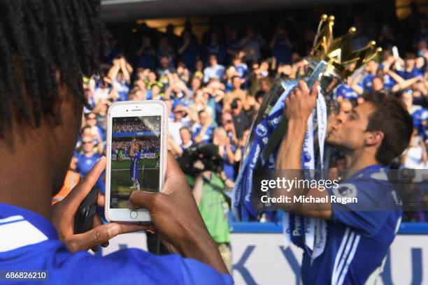 Nathaniel Chalobah of Chelsea takes a picture of team mate Cesar Azpilicueta and the Premier League Trophy on a phone after the Premier League match...