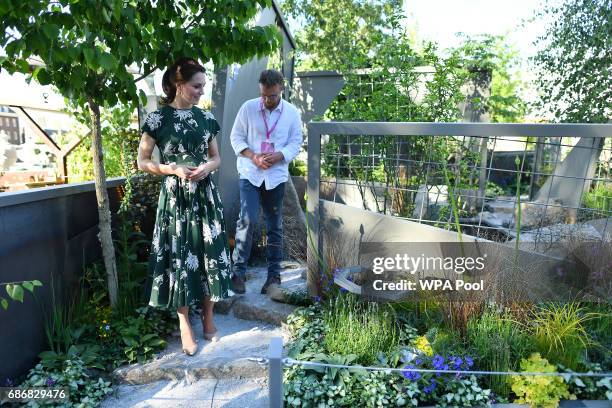 Catherine, Duchess of Cambridge talks with Northern Irish designer Ian Price as she views his garden 'Mind Trap' at the RHS Chelsea Flower Show press...