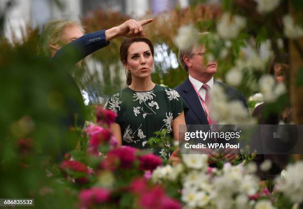 Catherine, Duchess of Cambridge reacts as she views a display of David Austin roses at the RHS Chelsea Flower Show press day at Royal Hospital...