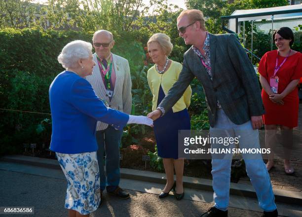 Britain's Queen Elizabeth II shakes hands with BBC Radio 2 presenter Chris Evans as she visits the BBC Radio 2 Feel Good Gardens at the Chelsea...
