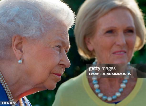 Britain's Queen Elizabeth II reacts as she greets British chef and television presenter Mary Berry as she visits the BBC Radio 2 Feel Good Gardens at...