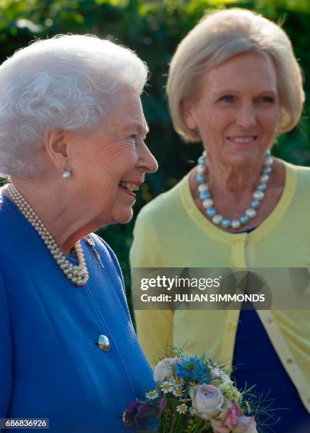 Britain's Queen Elizabeth II reacts as she greets British chef and television presenter Mary Berry as she visits the BBC Radio 2 Feel Good Gardens at...