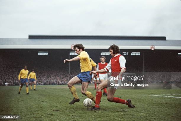 Arsenal player Peter Simpson is challenged by Kevin Hector of Derby during a First Divsion match between Arsenal and Derby County at Highbury on...