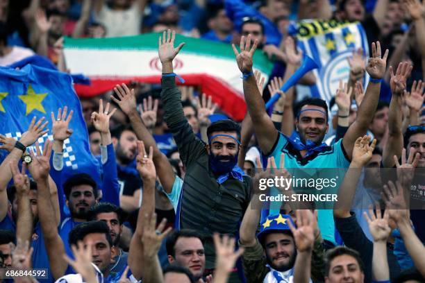 Fans of Esteghlal cheer during the 2017 AFC Champions League round 16 football match between Iran's Esteghlal FC and UAE's Al-Ain FC at the Azadi...