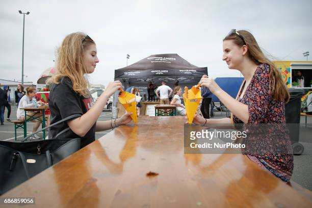 People are seen eating churros with chocolate sauce at a food truck rally in Bydgoszcz, Poland on 20 May, 2017.