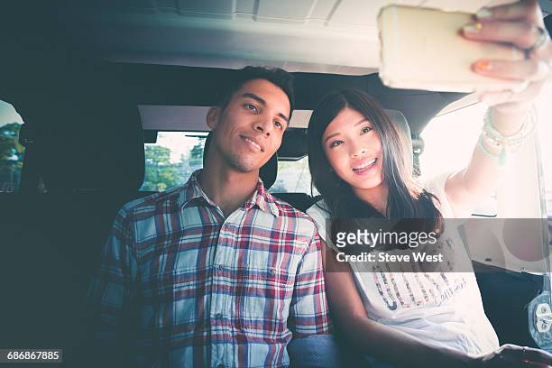 couple taking a selfie in the back of a car - west asia stock-fotos und bilder