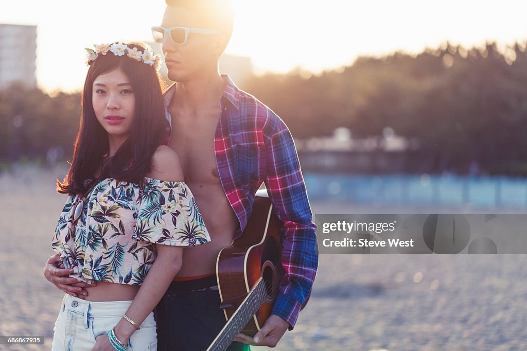 Young Carefree Couple Posing On Beach At Sunset