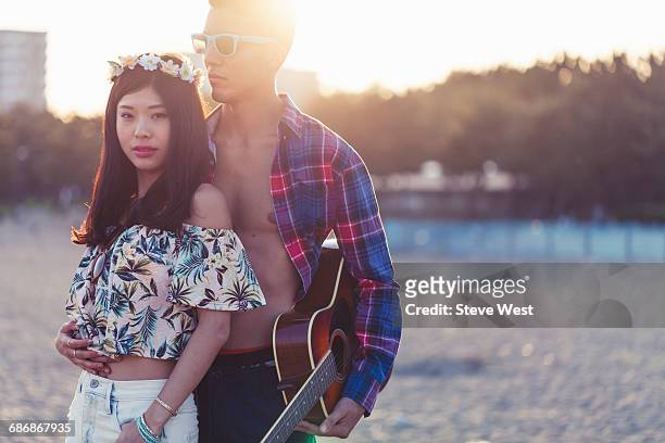 young carefree couple posing on beach at sunset - west asia stock-fotos und bilder
